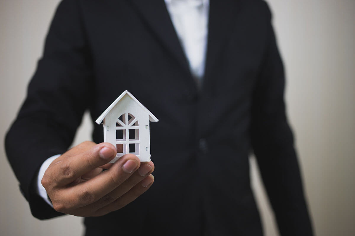 A man in a suit holding a tiny window frame in his hand