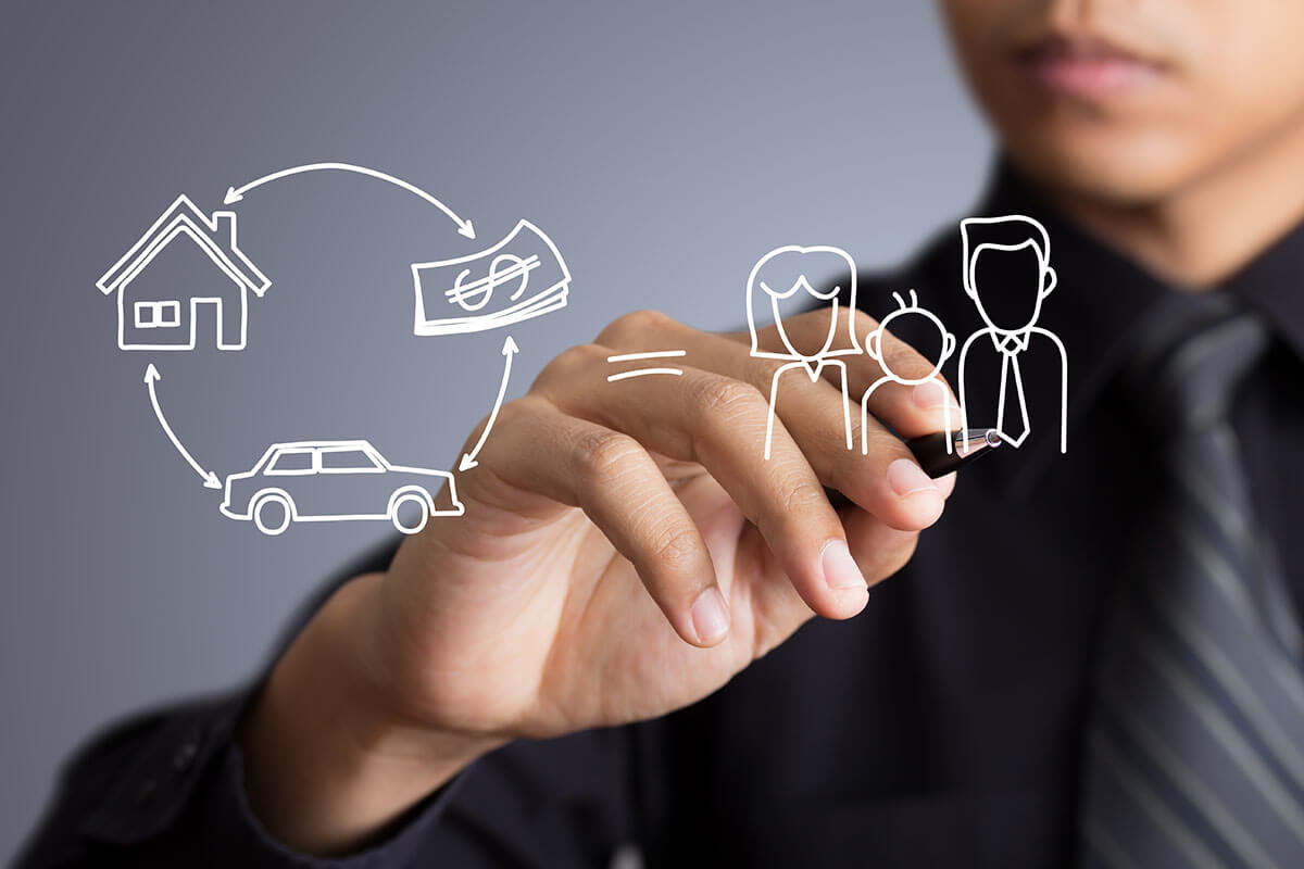 A man in a dress shirt and tie drawing a family next to a diagram of a house, stack of money, and a car to represent estate trust planning